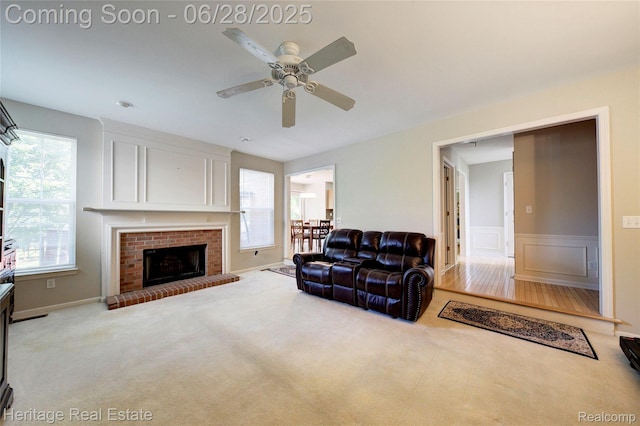 3400 Yosemite Dr, Lake Orion, MI 48360 - carpeted living room featuring a ceiling fan, a fireplace, wainscoting, and a decorative wall