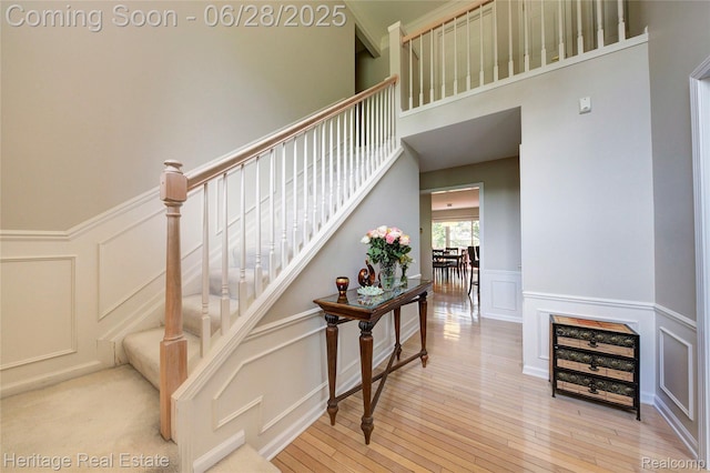 3400 Yosemite Dr, Lake Orion, MI 48360 - stairway featuring a decorative wall, wood-type flooring, wainscoting, and a towering ceiling