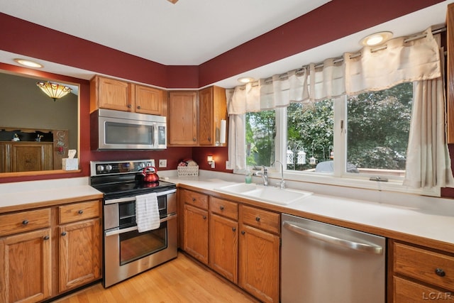 221 Burt St, Tecumseh, MI 49286 - kitchen with stainless steel appliances, light countertops, light wood-type flooring, and brown cabinetry
