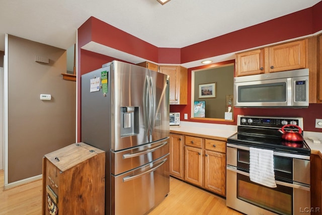 221 Burt St, Tecumseh, MI 49286 - kitchen featuring stainless steel appliances, light wood-style floors, light countertops, and brown cabinets