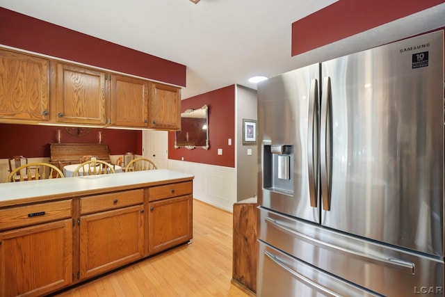 221 Burt St, Tecumseh, MI 49286 - kitchen featuring stainless steel fridge, brown cabinets, light wood-type flooring, a wainscoted wall, and light countertops