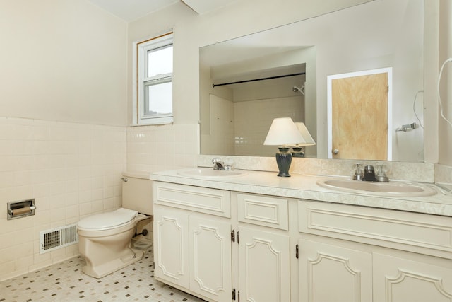 18210 Rainbow Dr, Lathrup Village, MI 48076 - bathroom featuring tile walls, double vanity, tile patterned floors, wainscoting, and a shower