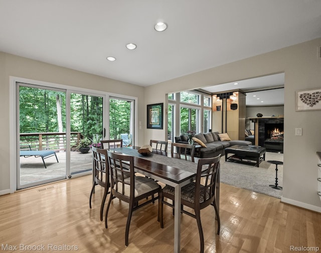 6224 Bromley Ct, West Bloomfield, MI 48322 - dining area featuring light wood-style flooring, recessed lighting, and a lit fireplace