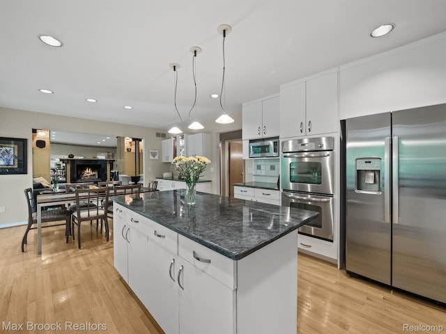 6224 Bromley Ct, West Bloomfield, MI 48322 - kitchen with stainless steel appliances, a kitchen island, white cabinets, light wood-style flooring, and recessed lighting
