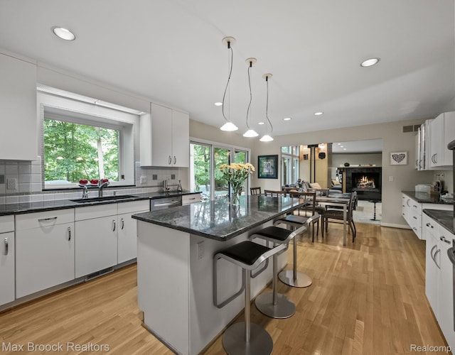 6224 Bromley Ct, West Bloomfield, MI 48322 - kitchen with decorative backsplash, white cabinetry, a center island, a kitchen breakfast bar, and recessed lighting