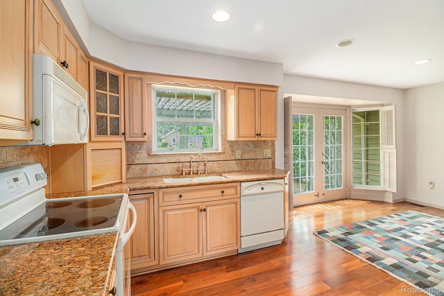 6392 Mckenzie Dr, Flint, MI 48507 - kitchen featuring white appliances, decorative backsplash, light wood-style floors, recessed lighting, and light stone counters