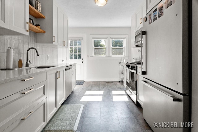 2036 Dawson Ave NE, Grand Rapids, MI 49505 - kitchen with appliances with stainless steel finishes, light countertops, tasteful backsplash, and white cabinetry