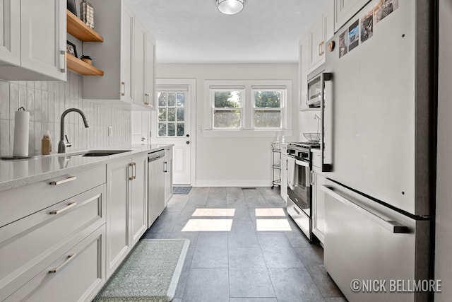 2036 Dawson Ave NE, Grand Rapids, MI 49505 - kitchen featuring appliances with stainless steel finishes, open shelves, light countertops, tasteful backsplash, and white cabinetry