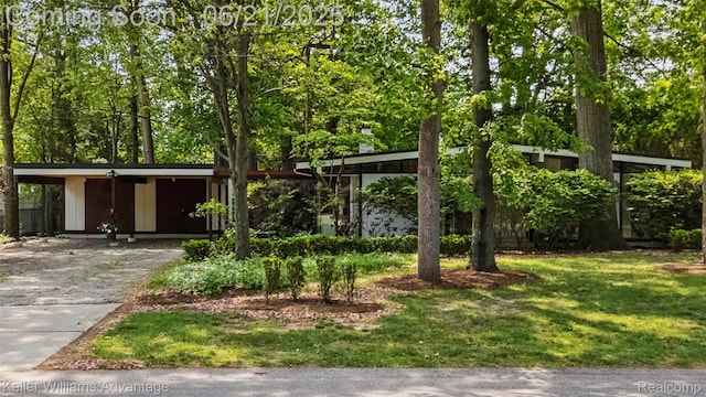 5959 Rosetta St, Dearborn Heights, MI 48127 - view of front of home featuring concrete driveway, a front lawn, a carport, and view of wooded area