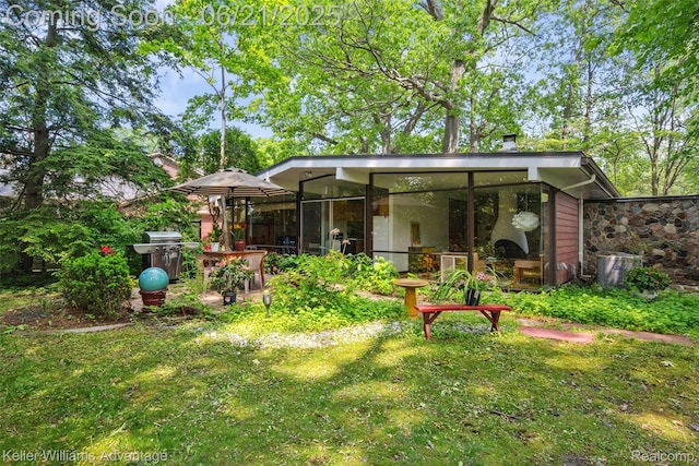 5959 Rosetta St, Dearborn Heights, MI 48127 - back of property with a sunroom and a lawn
