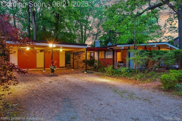5959 Rosetta St, Dearborn Heights, MI 48127 - mid-century modern home with an attached carport, dirt driveway, and a chimney