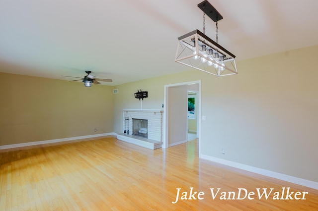 6835 Countryview Dr, Kalamazoo, MI 49009 - unfurnished living room featuring a brick fireplace, ceiling fan, and light wood-style floors