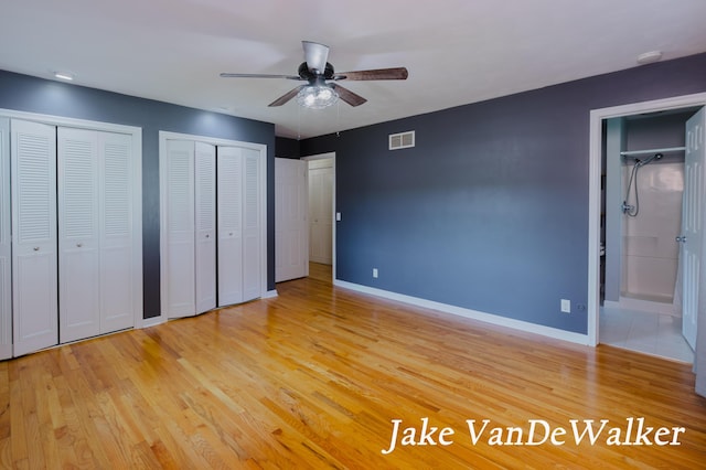6835 Countryview Dr, Kalamazoo, MI 49009 - unfurnished bedroom with multiple closets, light wood-style flooring, ensuite bath, and ceiling fan