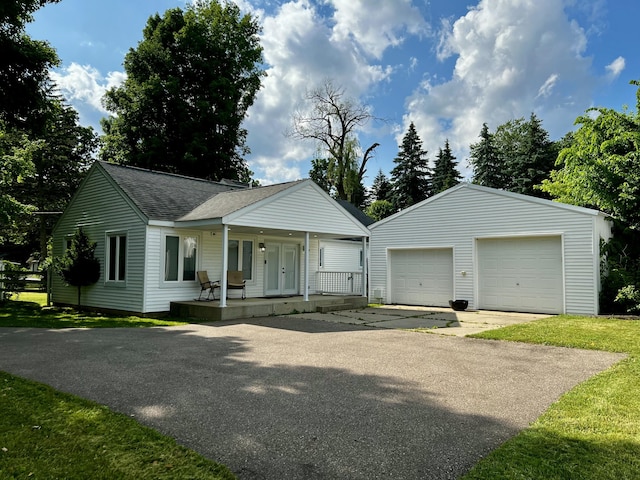 9910 8 Mile Rd, Ceresco, MI 49033 - ranch-style house with a shingled roof, a detached garage, a porch, and an outdoor structure