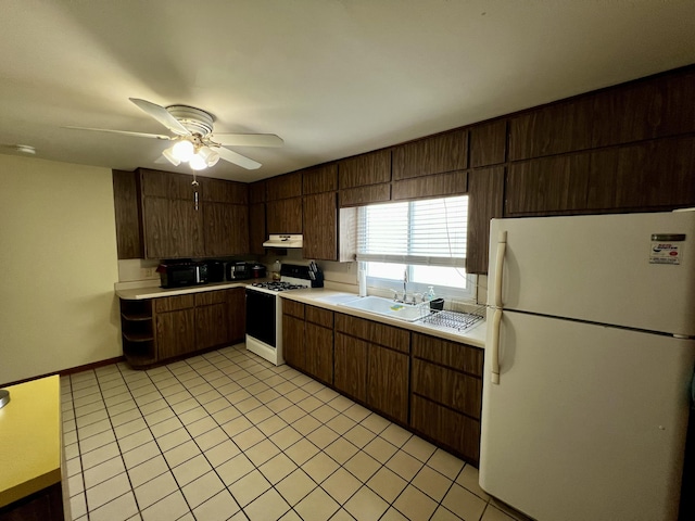 9910 8 Mile Rd, Ceresco, MI 49033 - kitchen featuring freestanding refrigerator, gas range, under cabinet range hood, light countertops, and light tile patterned floors