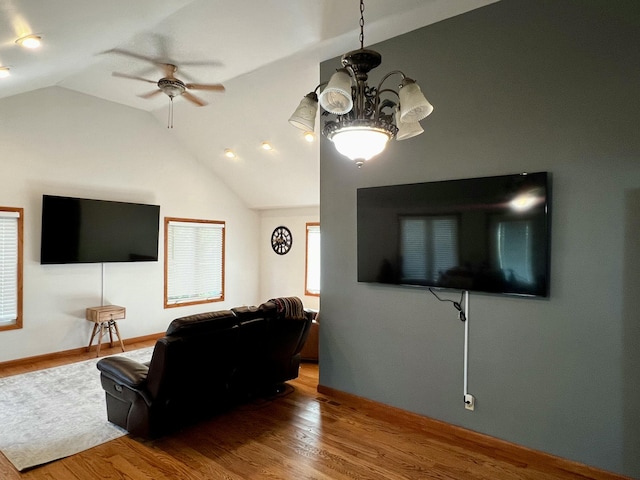 9910 8 Mile Rd, Ceresco, MI 49033 - living room with ceiling fan, vaulted ceiling, wood finished floors, and a chandelier