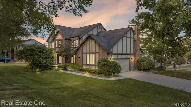 25006 Davenport Ave, Novi, MI 48374 - tudor home featuring a front yard, driveway, a garage, and a shingled roof