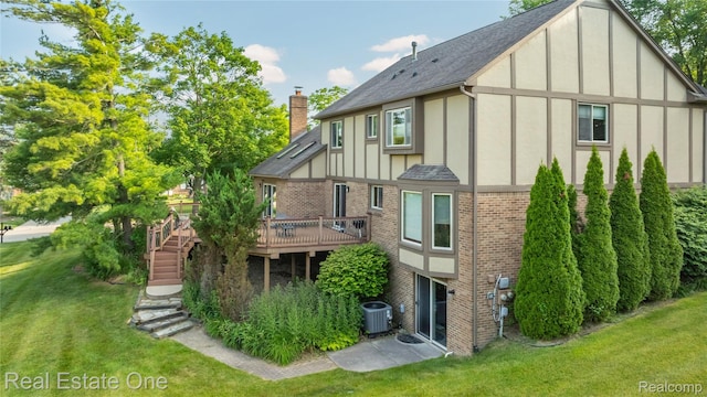 25006 Davenport Ave, Novi, MI 48374 - back of property with brick siding, a chimney, a deck, board and batten siding, and a yard