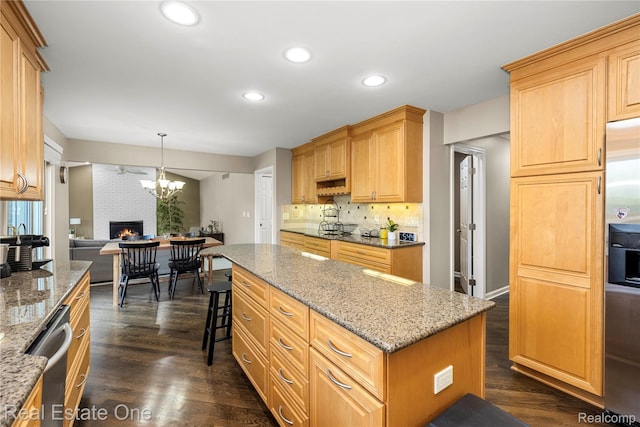 25006 Davenport Ave, Novi, MI 48374 - kitchen with recessed lighting, a brick fireplace, dark wood-style flooring, light stone counters, and stainless steel dishwasher