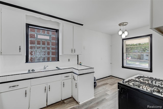 9938 Bramell, Redford, MI 48239 - kitchen with black range with gas cooktop, decorative backsplash, light wood-style flooring, and white cabinets