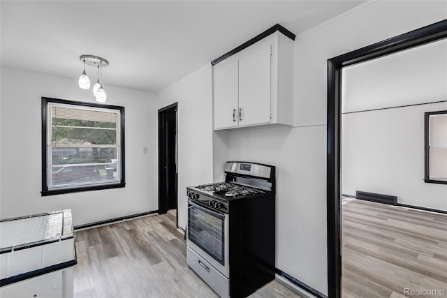 9938 Bramell, Redford, MI 48239 - kitchen featuring stainless steel gas range oven, white cabinets, light wood-style flooring, and pendant lighting