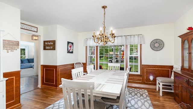 4561 Ashland Dr, Saginaw, MI 48638 - dining area featuring a chandelier, wood finished floors, plenty of natural light, and a wainscoted wall
