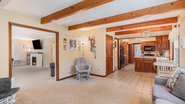 4561 Ashland Dr, Saginaw, MI 48638 - living room with a chandelier, a lit fireplace, beam ceiling, and light carpet