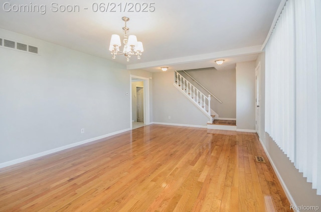 37718 Douglas Ct, Sterling Heights, MI 48310 - unfurnished room featuring a chandelier, light wood-style flooring, and stairway