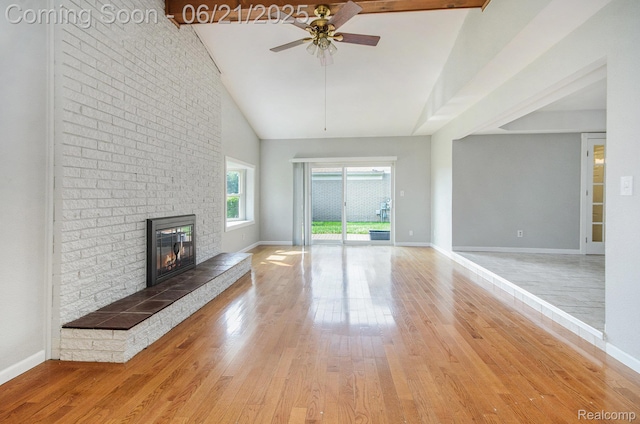 37718 Douglas Ct, Sterling Heights, MI 48310 - unfurnished living room featuring a ceiling fan, high vaulted ceiling, a brick fireplace, and light wood-type flooring