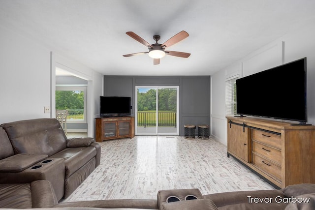 6770 Rivers Edge Ln, Middleville, MI 49333 - living room featuring a ceiling fan, healthy amount of natural light, light wood-style floors, and a decorative wall