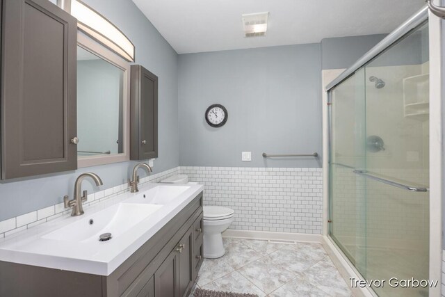 6770 Rivers Edge Ln, Middleville, MI 49333 - bathroom with a stall shower, vanity, tile walls, and wainscoting