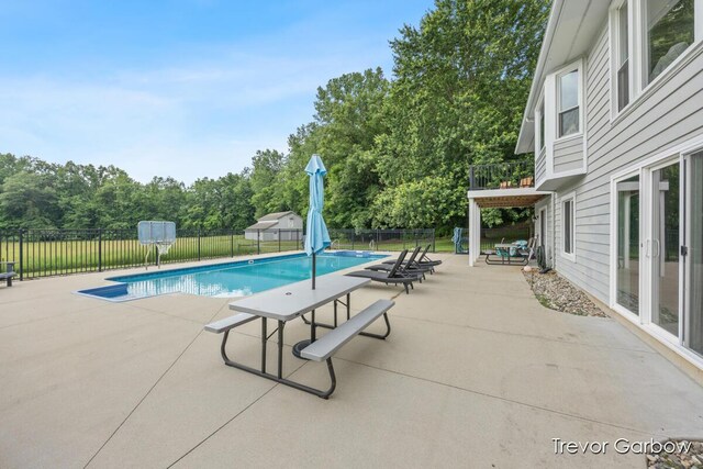 6770 Rivers Edge Ln, Middleville, MI 49333 - view of swimming pool featuring a fenced backyard, a patio, view of scattered trees, and french doors