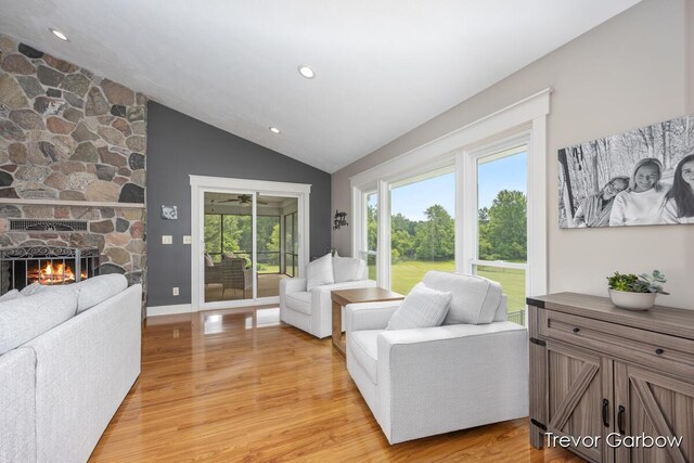 6770 Rivers Edge Ln, Middleville, MI 49333 - living room featuring lofted ceiling, light wood-style flooring, a stone fireplace, and recessed lighting