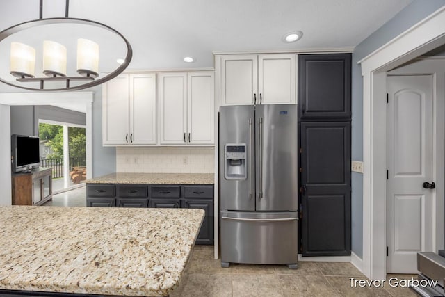 6770 Rivers Edge Ln, Middleville, MI 49333 - kitchen with high end refrigerator, backsplash, recessed lighting, white cabinetry, and light stone counters