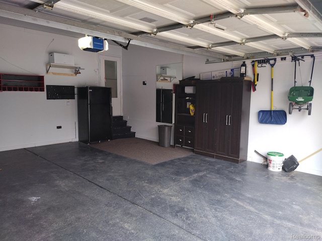 8993 Haymarket St, White Lake, MI 48386 - garage with a garage door opener and freestanding refrigerator