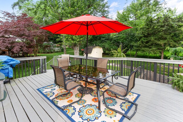 525 Langfield St, Northville, MI 48167 - wooden terrace with outdoor dining area, a storage shed, a lawn, and view of scattered trees