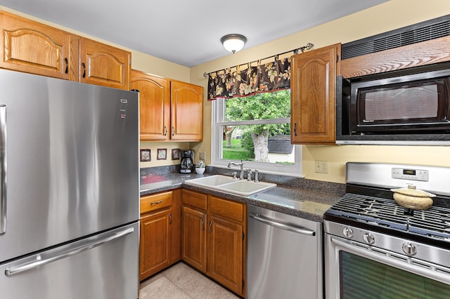 525 Langfield St, Northville, MI 48167 - kitchen featuring appliances with stainless steel finishes, light tile patterned floors, and brown cabinetry