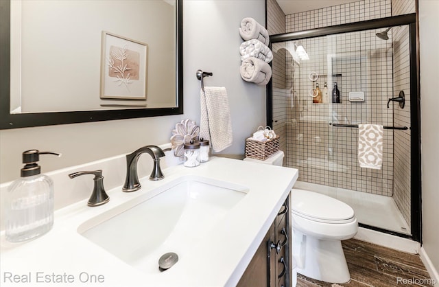 1106 Kings Cove Dr Unit 355, Rochester, MI 48306 - bathroom featuring a stall shower, vanity, and wood finished floors