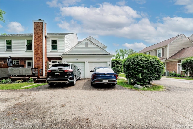 1106 Kings Cove Dr Unit 355, Rochester, MI 48306 - view of front of property featuring a garage, driveway, and brick siding
