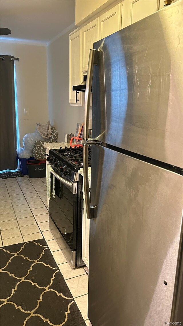 36014 Chapel Ct, Clinton Township, MI 48035 - kitchen featuring freestanding refrigerator, light tile patterned floors, black range with gas cooktop, white cabinetry, and crown molding