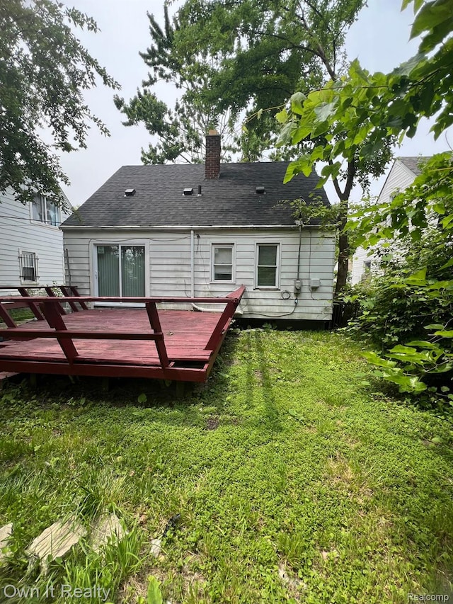 8620 Fielding St, Detroit, MI 48228 - back of house with a lawn, a wooden deck, a chimney, and a shingled roof