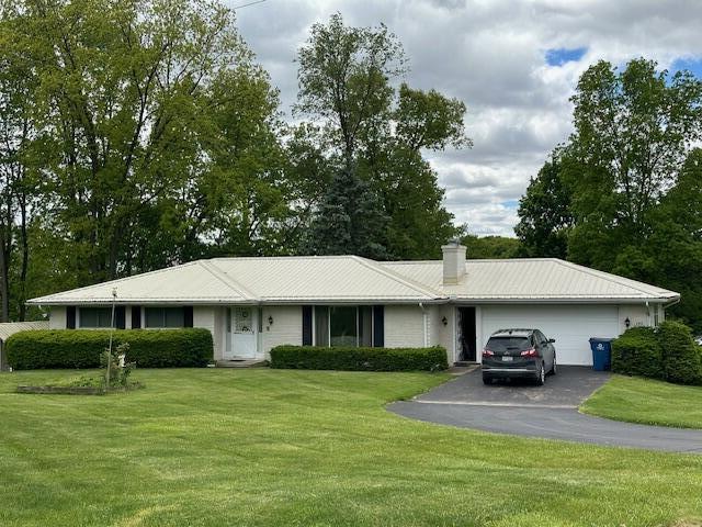 395 Hyannis Hills Dr, Tekonsha, MI 49092 - ranch-style home with driveway, a garage, and a front lawn