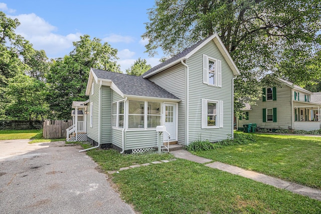 556 Union St, Niles, MI 49120 - traditional-style house featuring a shingled roof, a front lawn, and a sunroom