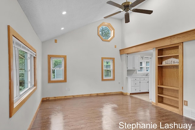 169 S Linda St NE, Cedar Springs, MI 49319 - unfurnished living room featuring wood finished floors, a ceiling fan, built in features, high vaulted ceiling, and recessed lighting