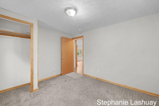169 S Linda St NE, Cedar Springs, MI 49319 - unfurnished bedroom with carpet floors, a closet, and a textured ceiling