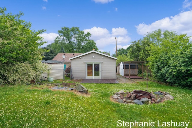 169 S Linda St NE, Cedar Springs, MI 49319 - rear view of house featuring an outdoor fire pit, a yard, and a storage unit