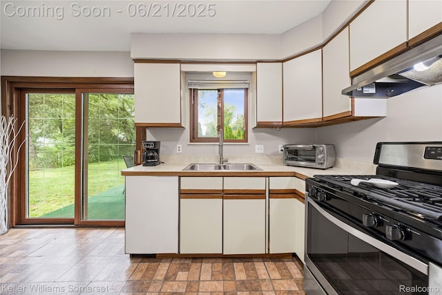 3123 W Utica Rd, Shelby Twp, MI 48317 - kitchen with stainless steel range with gas stovetop, under cabinet range hood, light countertops, and white cabinets