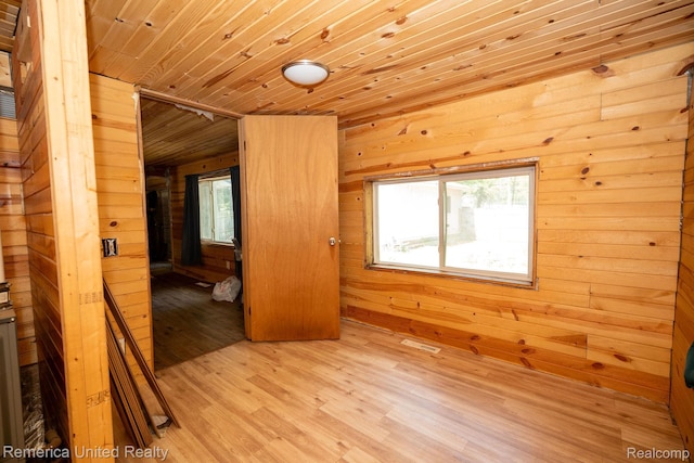 106 Devonshire Dr, Prudenville, MI 48651 - empty room with wood walls, wood ceiling, and light wood-style floors