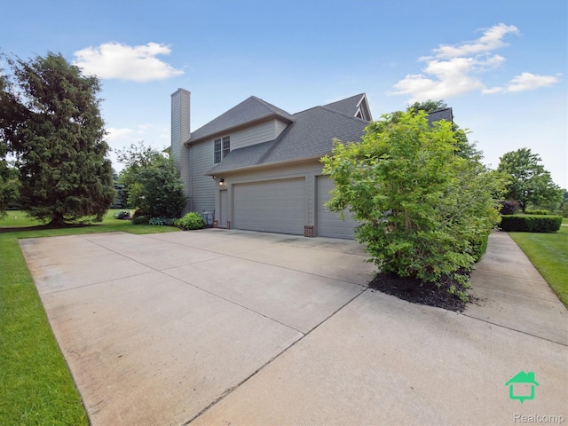 6345 Brookview Dr, Saline, MI 48176 - view of side of property with driveway, an attached garage, a chimney, a shingled roof, and a yard
