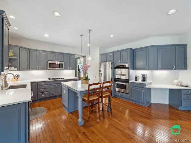 6345 Brookview Dr, Saline, MI 48176 - kitchen with stainless steel appliances, a center island, a breakfast bar area, backsplash, and light countertops